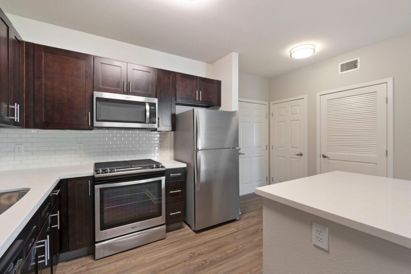 A kitchen with a stainless steel refrigerator and oven.