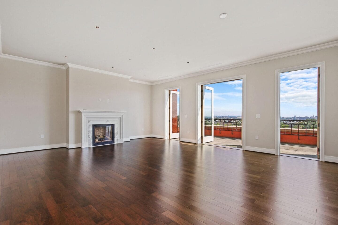 an empty living room with a fireplace and wooden floors