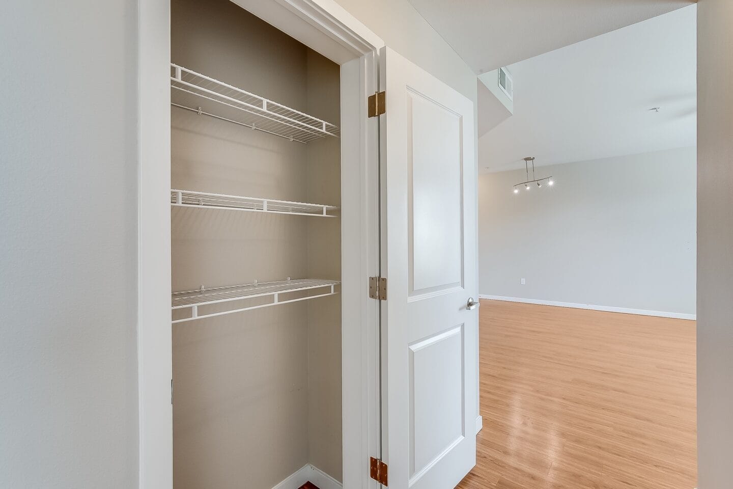 an empty closet with a white door and a wood floor