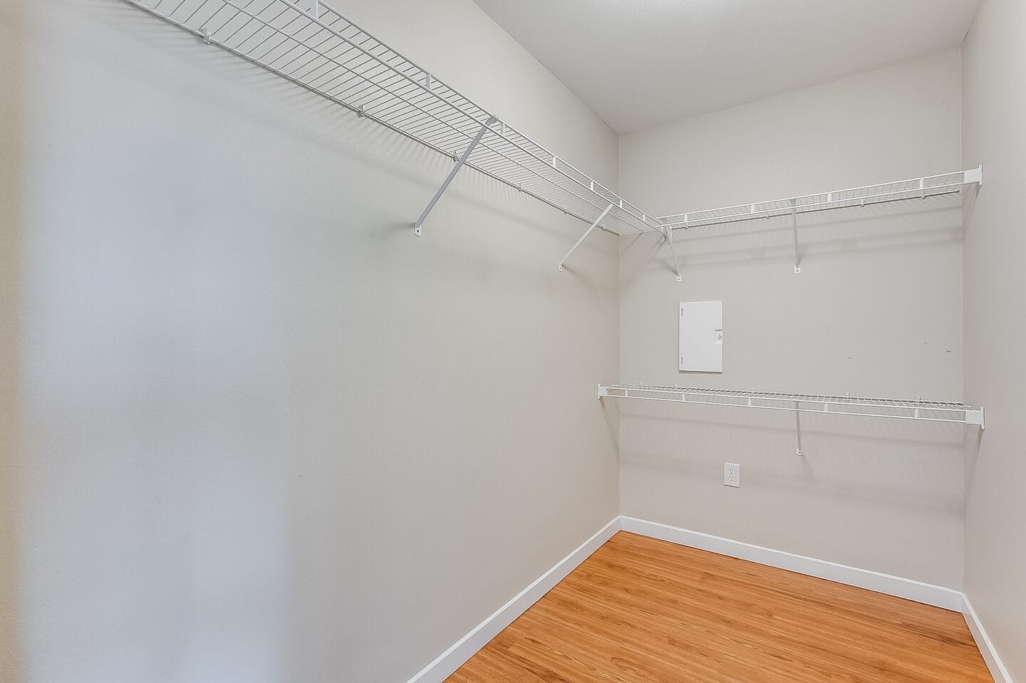 an empty room with white walls and wood flooring and a closet