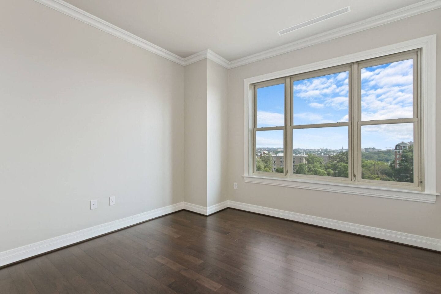 an empty living room with wood floors and a window