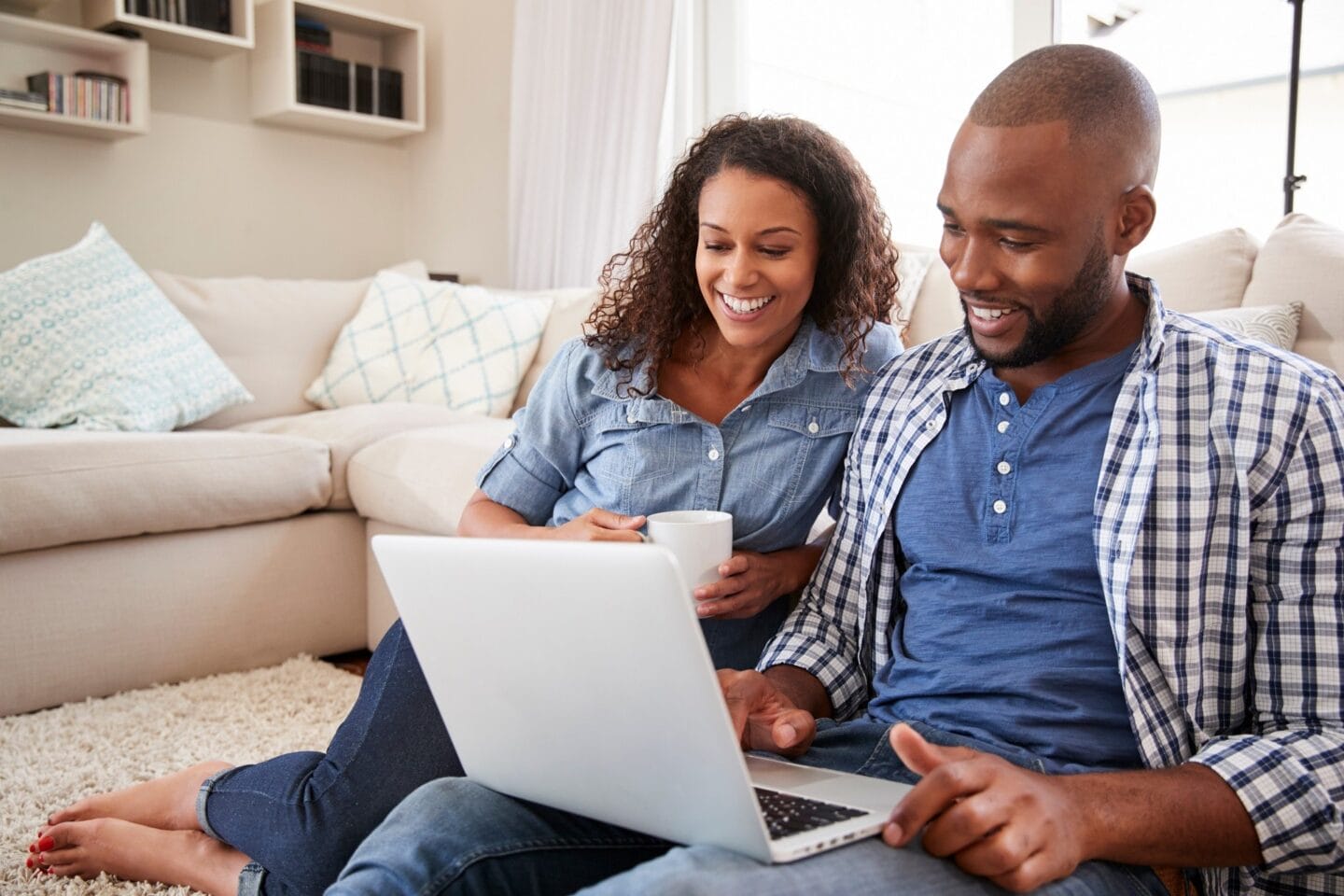 Man and woman sitting on the floor using a laptop computer