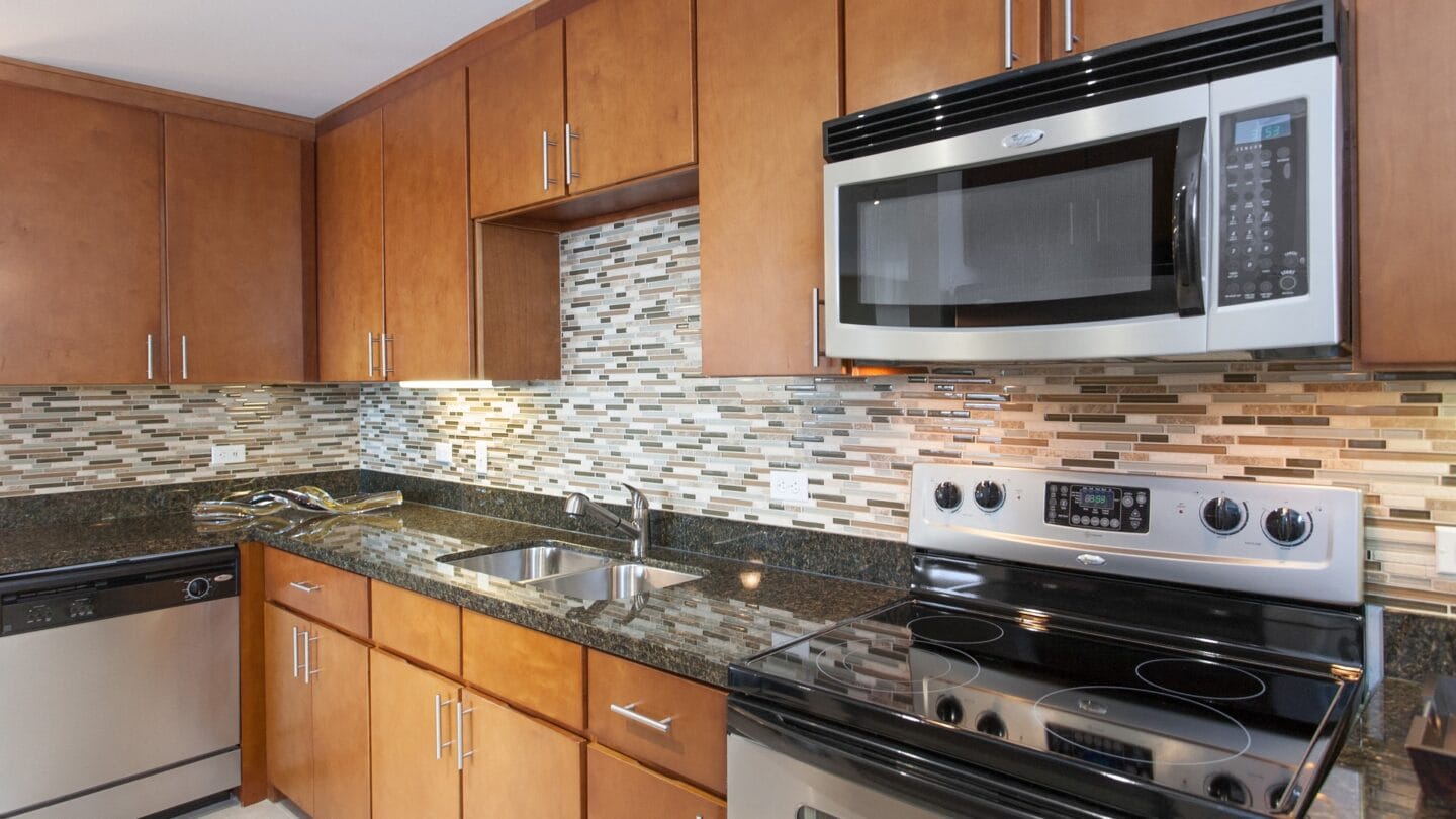 The gourmet kitchen with stainless steel appliances and tiled backsplash, at THE MONARCH BY WINDSOR, 801 West Fifth Street, Austin, 78703