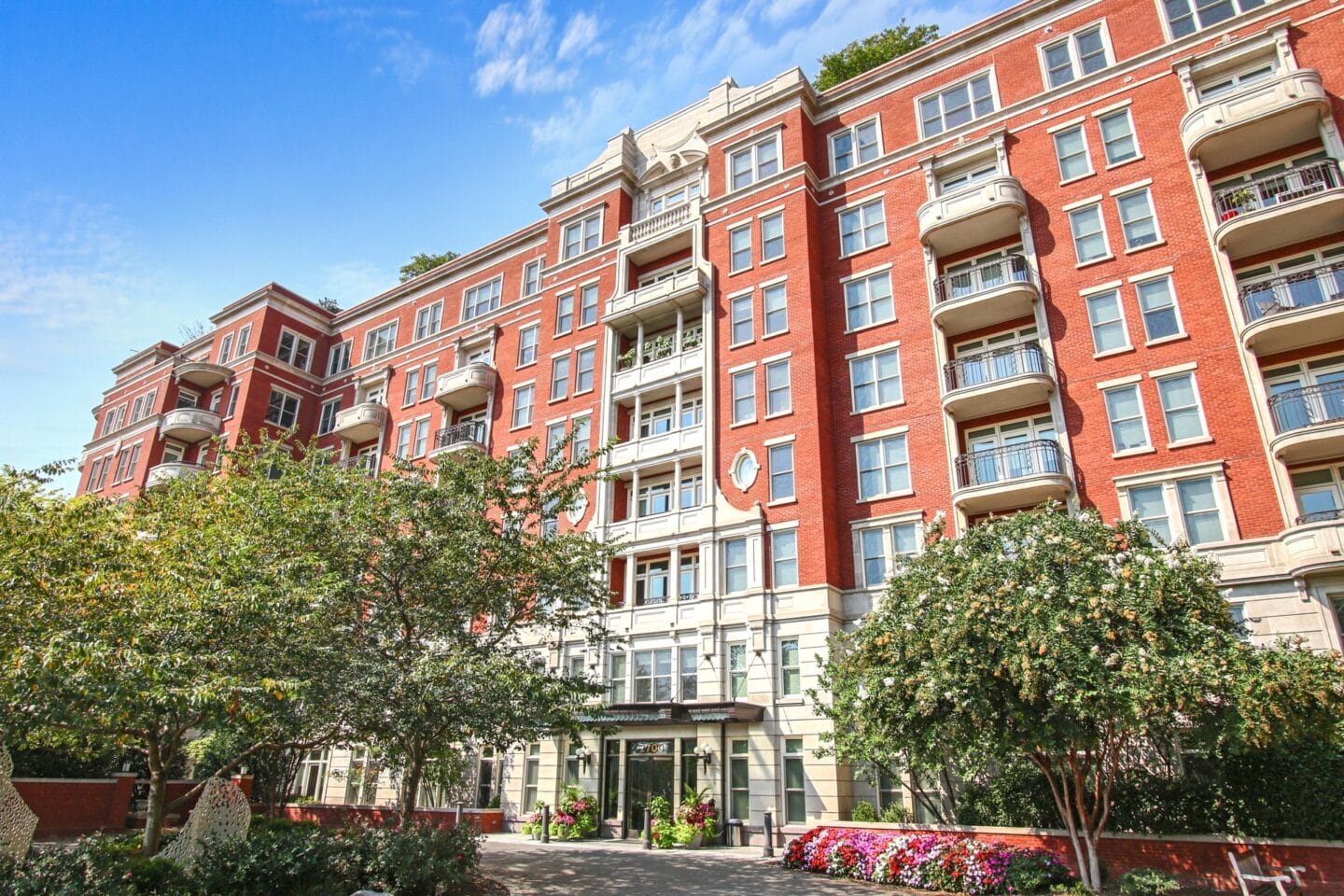 a large red brick apartment building with trees in front of it