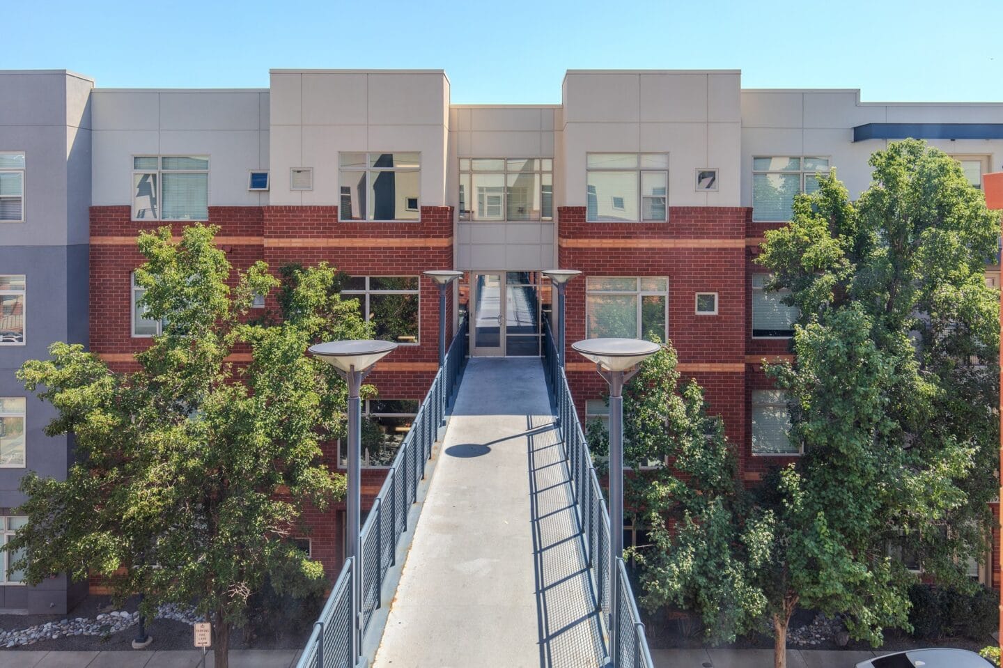 a bridge connects two buildings with trees in the middle