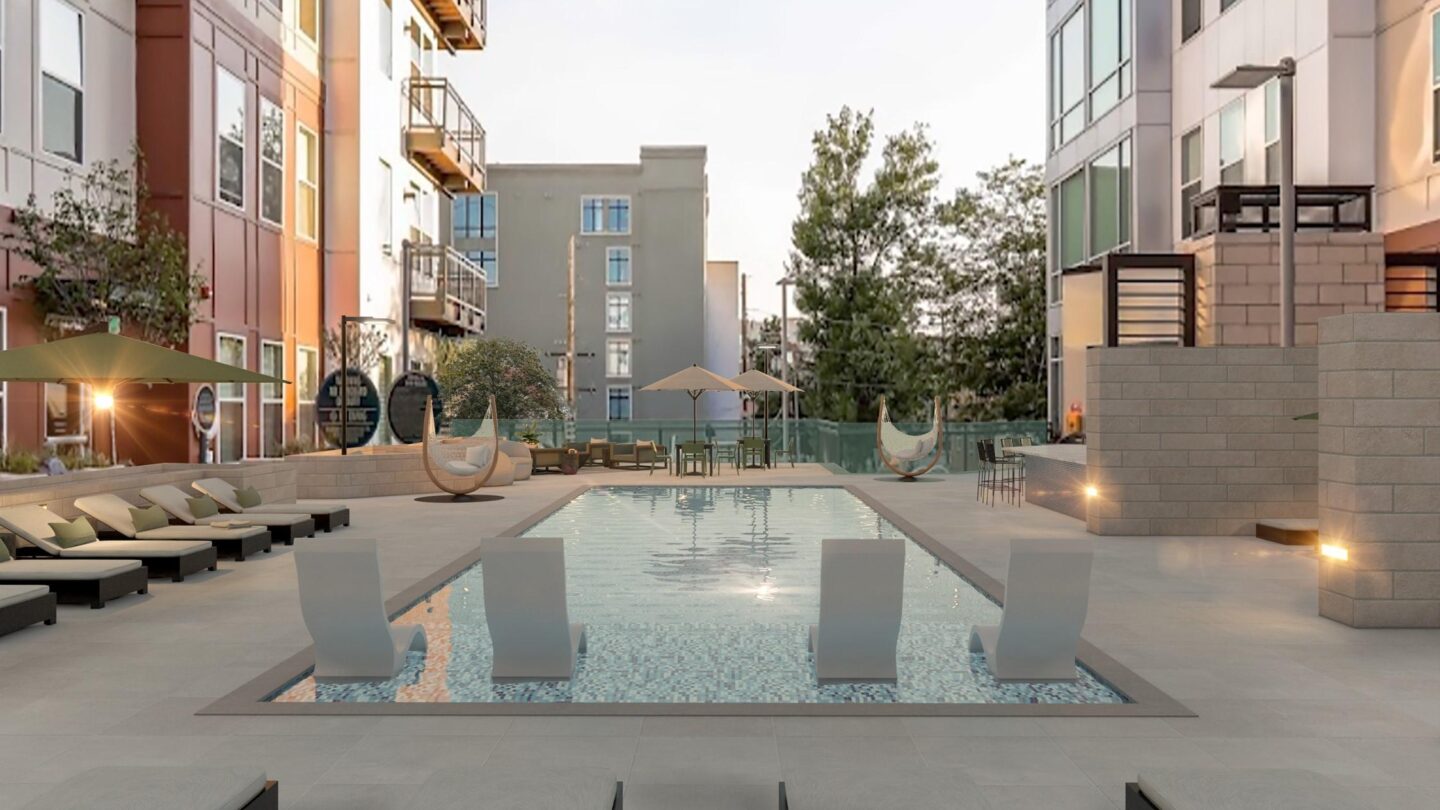 A modern courtyard with a pool and lounge chairs.