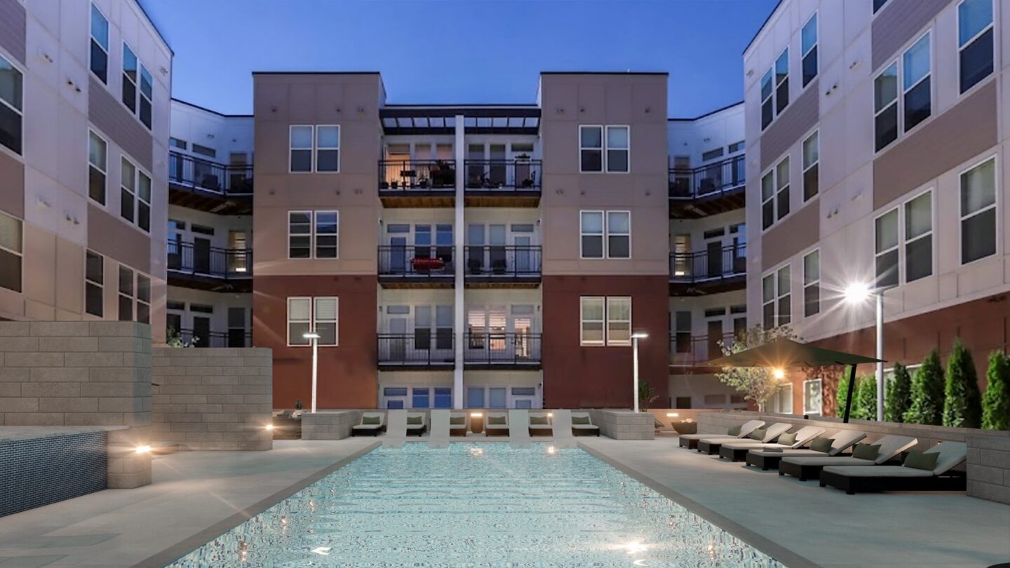 A large building with a pool in front of it.