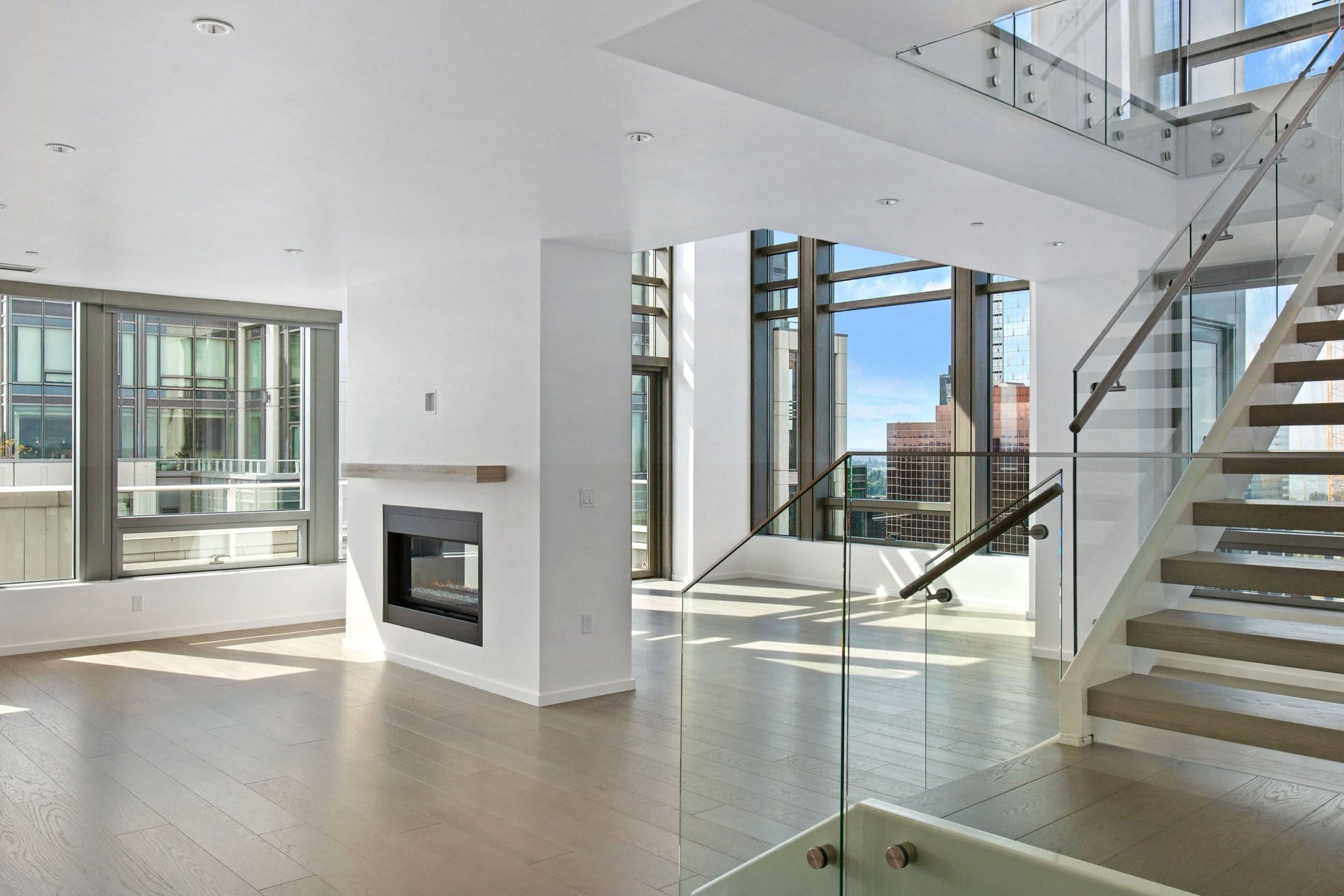 A large living room with a staircase and a fireplace at Bravern, Bellevue, Washington