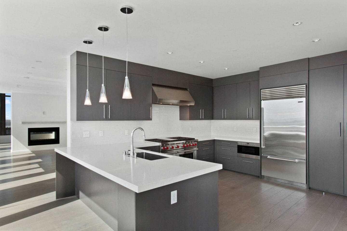 A modern kitchen with dark gray cabinets and white countertops at Bravern, Bellevue, Washington