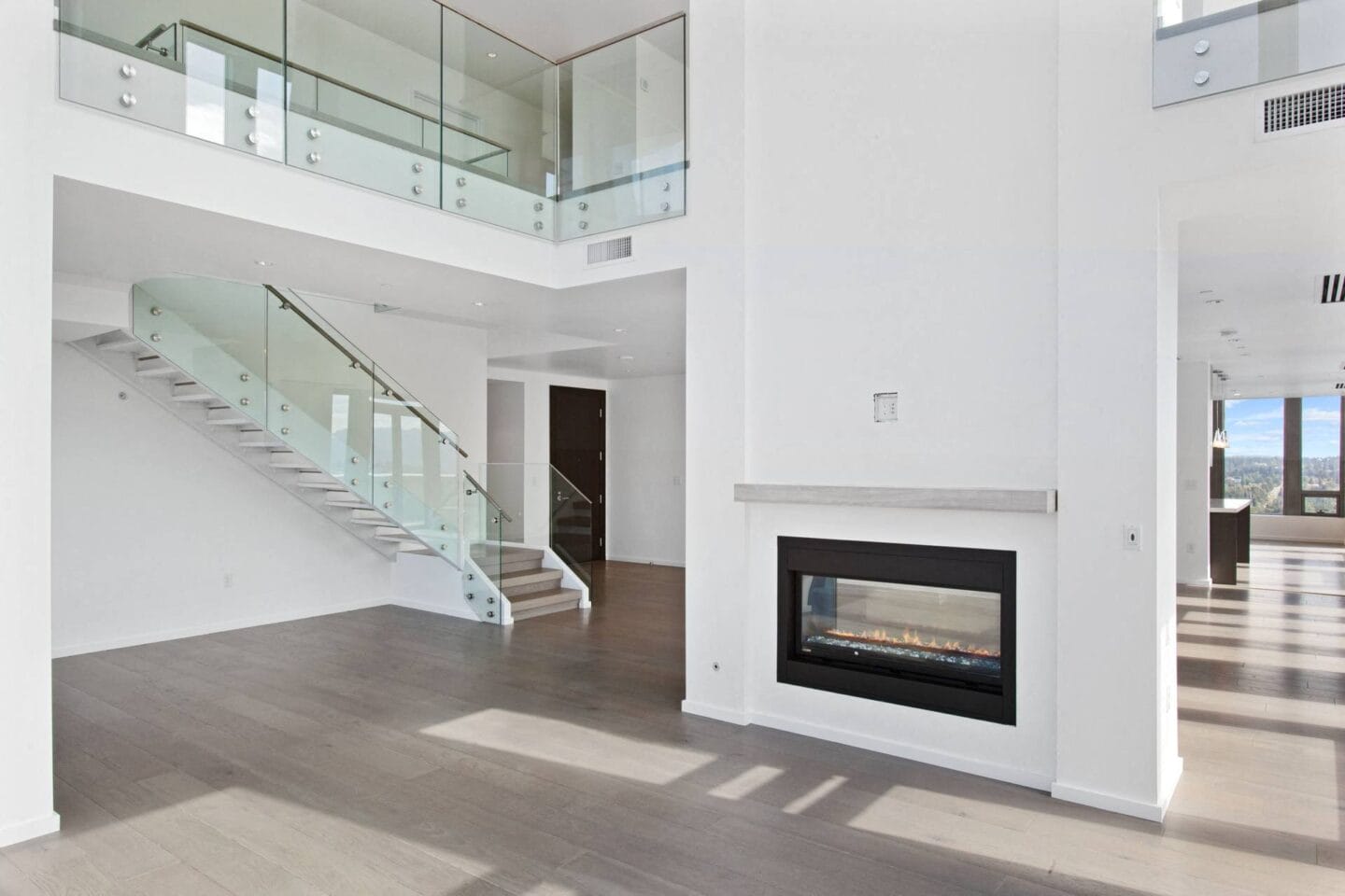 a large living room with a staircase and a fireplace