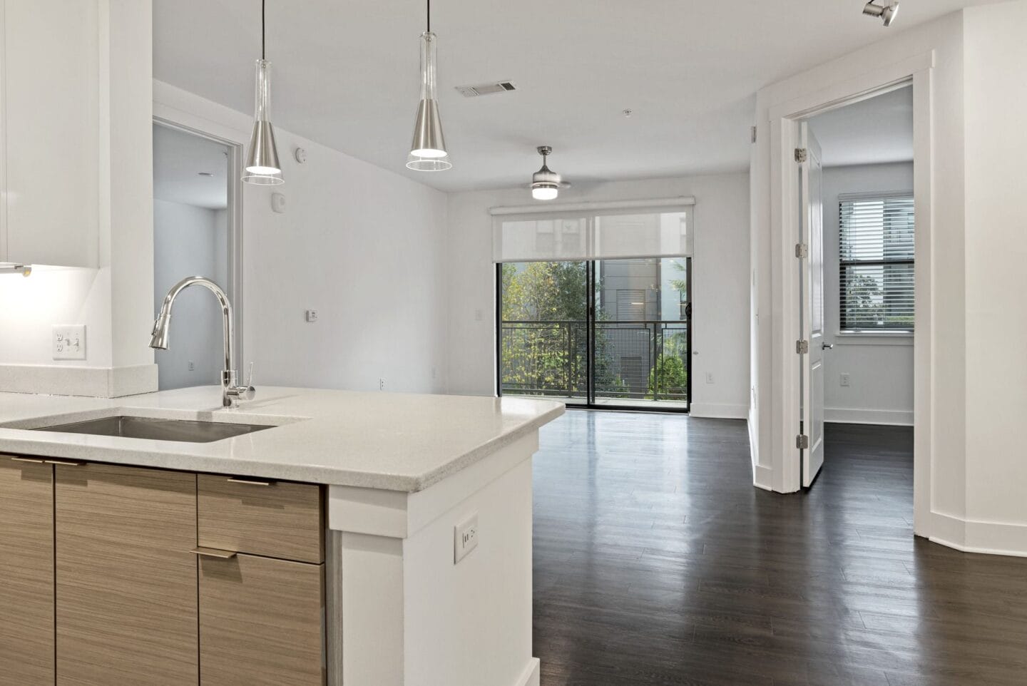 An empty kitchen with a sink and a door to a living room at Windsor Encore, Atlanta, 30339