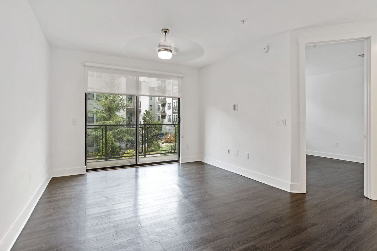 An empty living room with a large window and a balcony at Windsor Encore, Atlanta, 30339