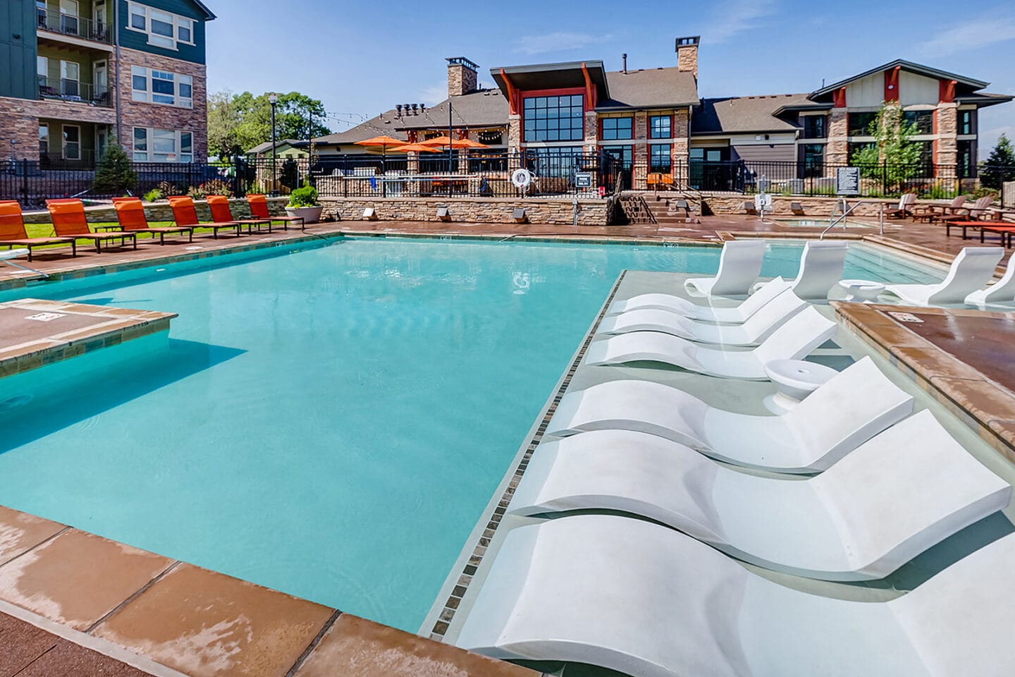 Pool with in water lounge chairs at Windsor at Pinehurst, Lakewood, Colorado