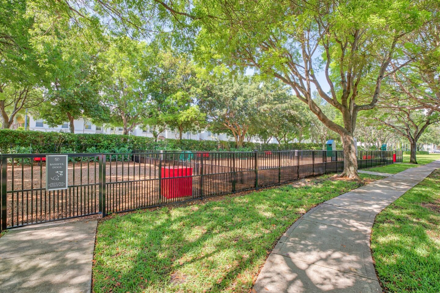 Large fenced in dog park in a shady tree area