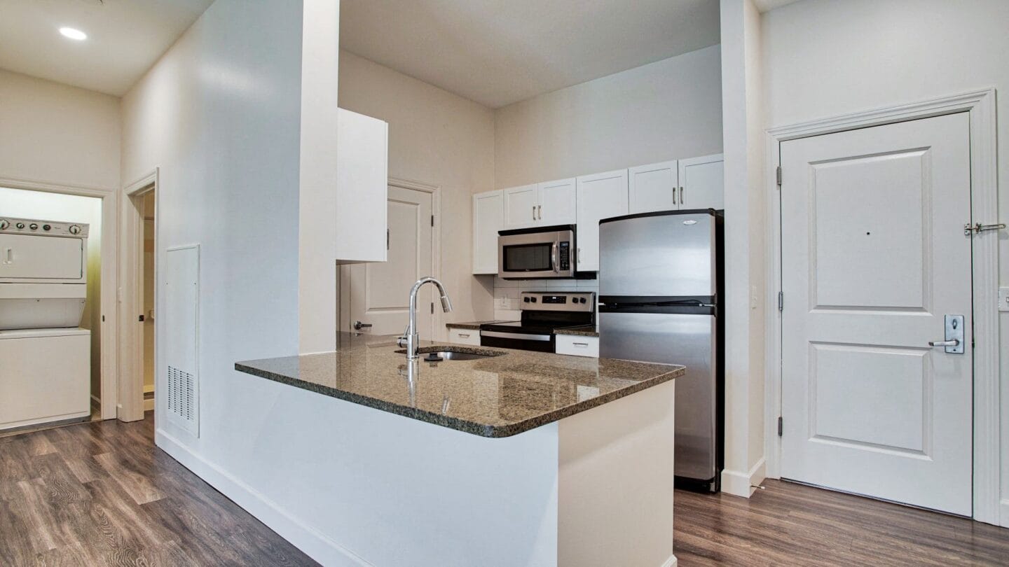 a kitchen with white cabinets and a granite counter top