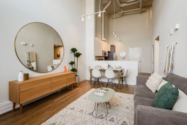 a living room with a couch and a table and a mirror