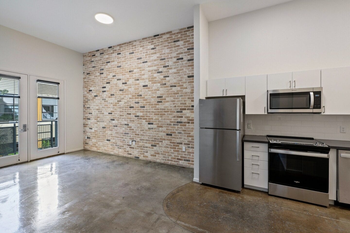 Open concept industrial looking living room with kitchen in shot at Terraces at Paseo Colorado, California, 91101