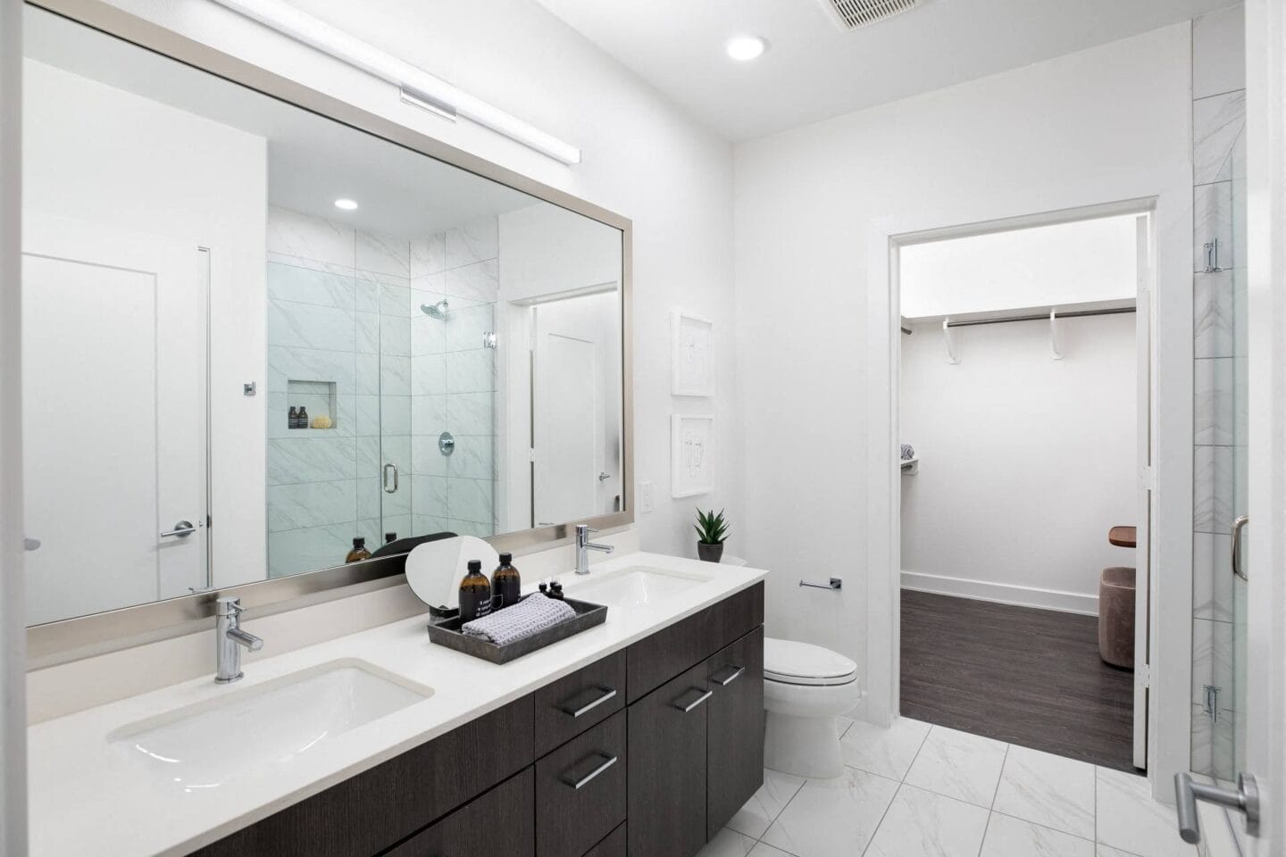 A bathroom with a large mirror and two sinks at The Sterling, Houston, TX 77019