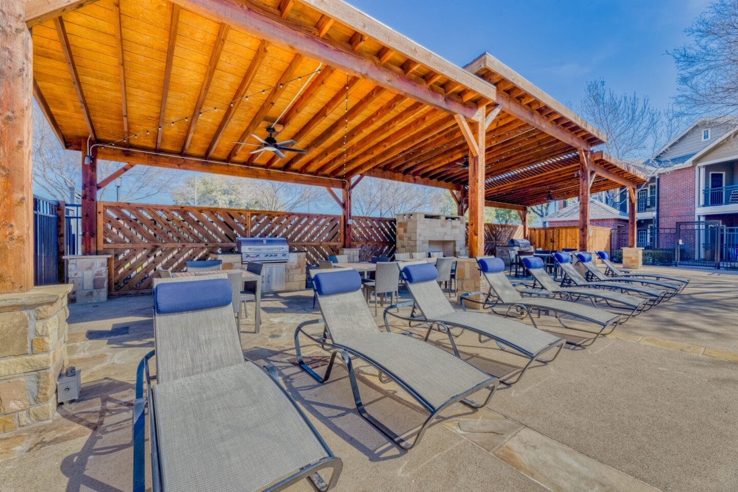 Covered patio with lounge chairs and grill at Windsor Westbridge, Carrollton, TX