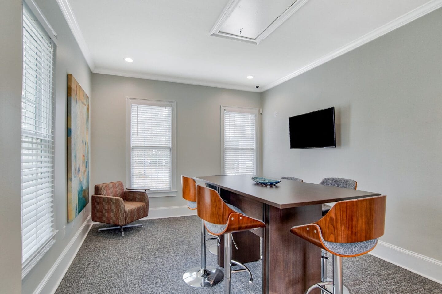 a room with a table and chairs and a tv on the wall