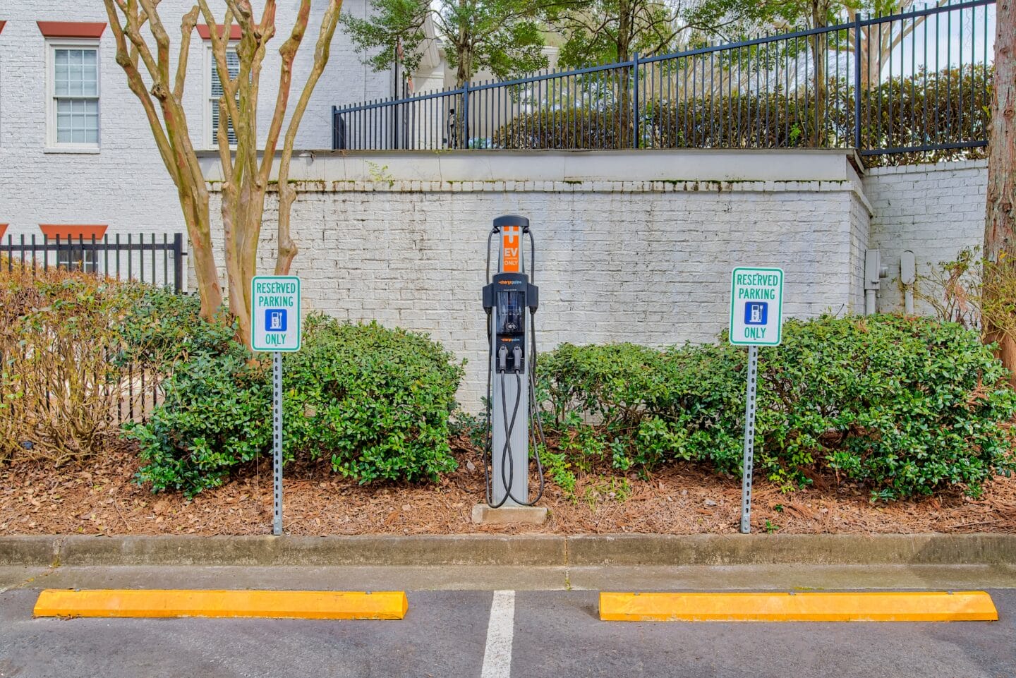 a parking meter in front of a white brick building