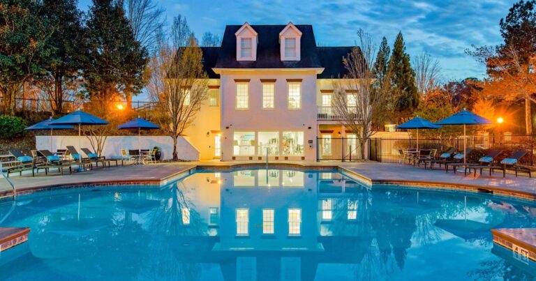 a mansion with a large pool in front of it