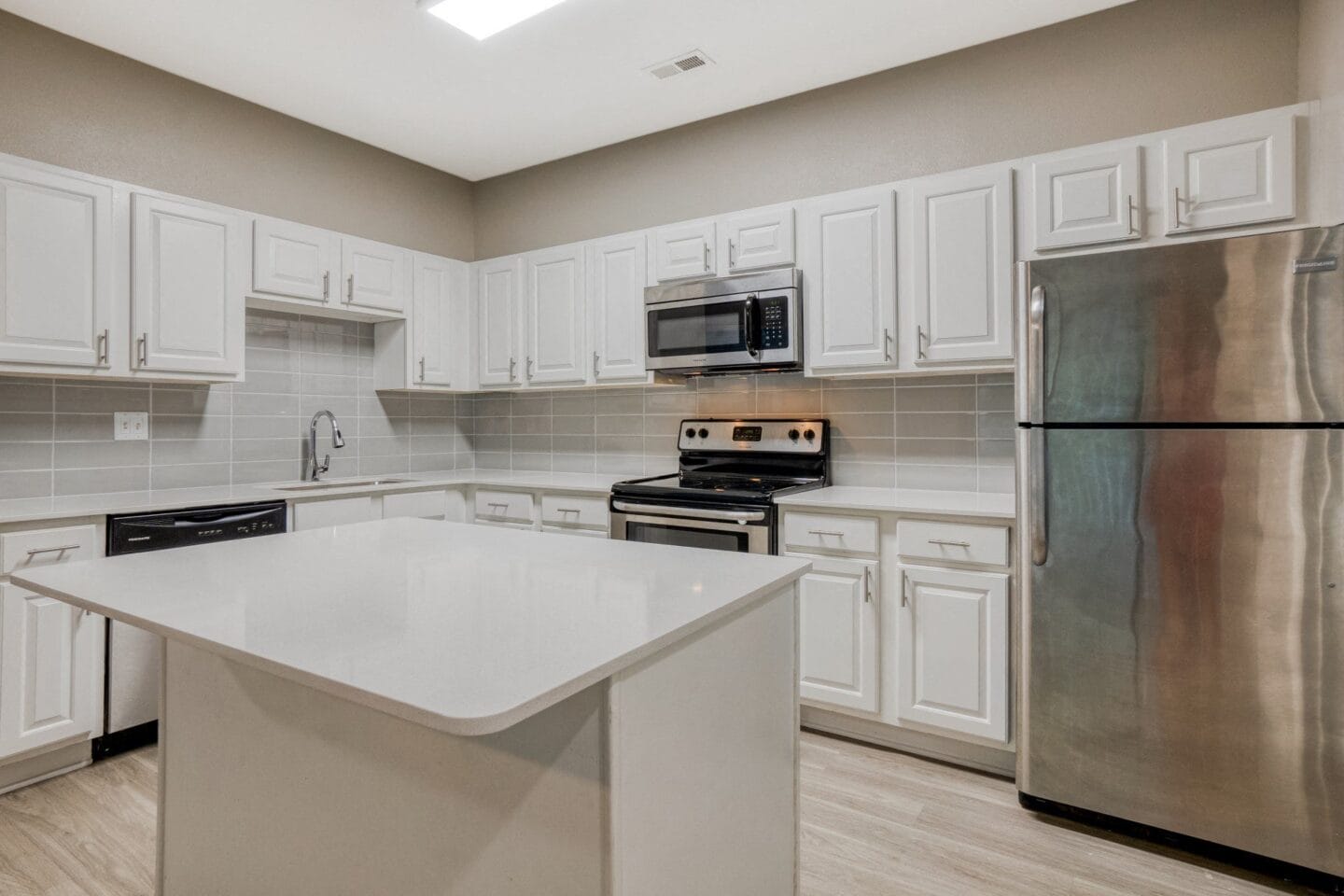 Quartz countertops stainless steel appliances in kitchen