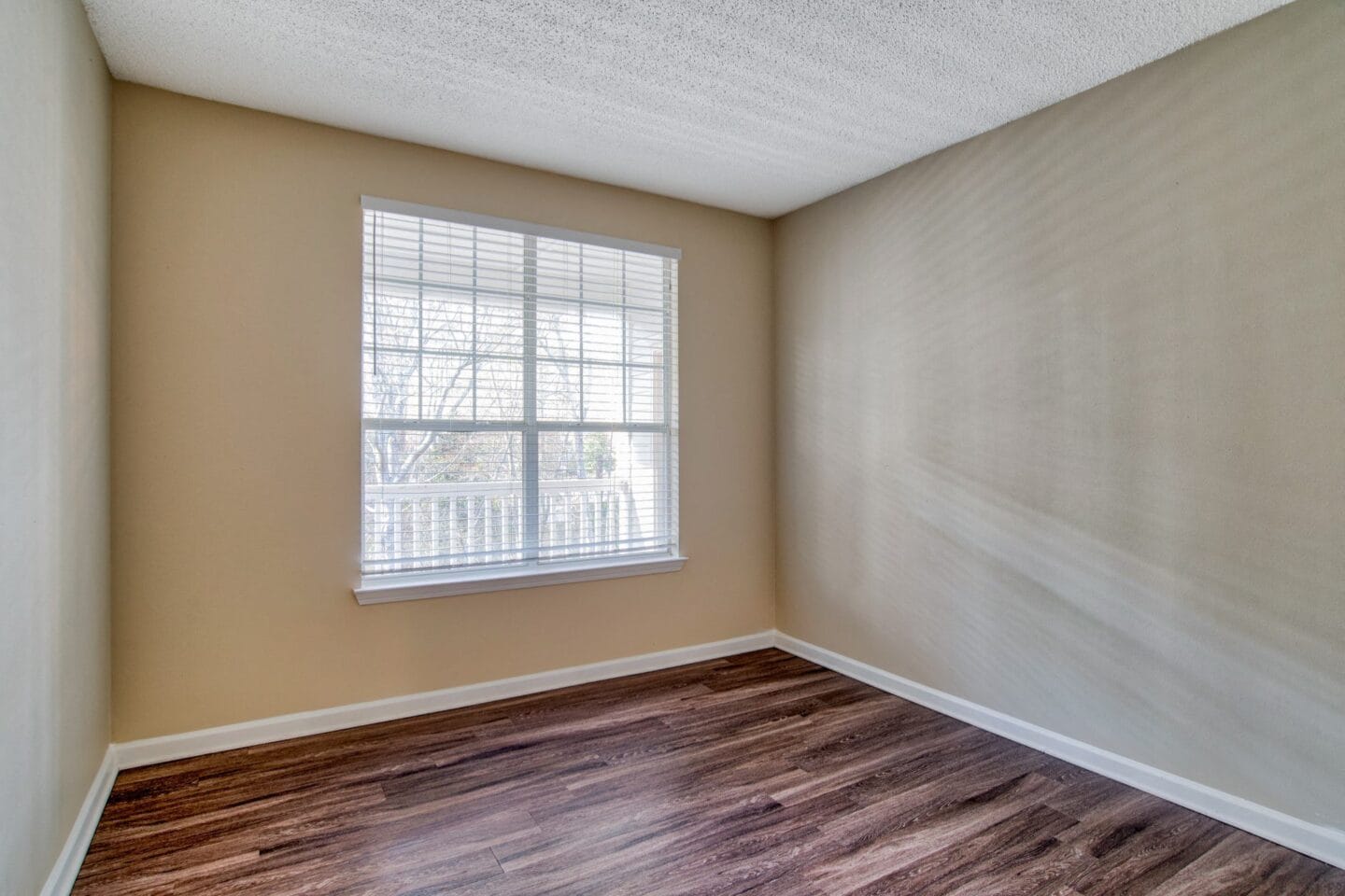 a bedroom with hardwood floors and a large window