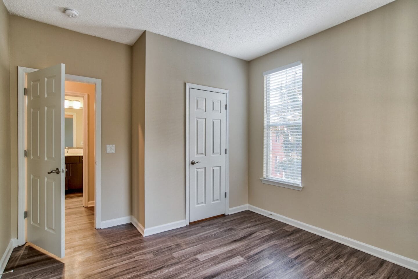 a bedroom with hardwood floors and a door