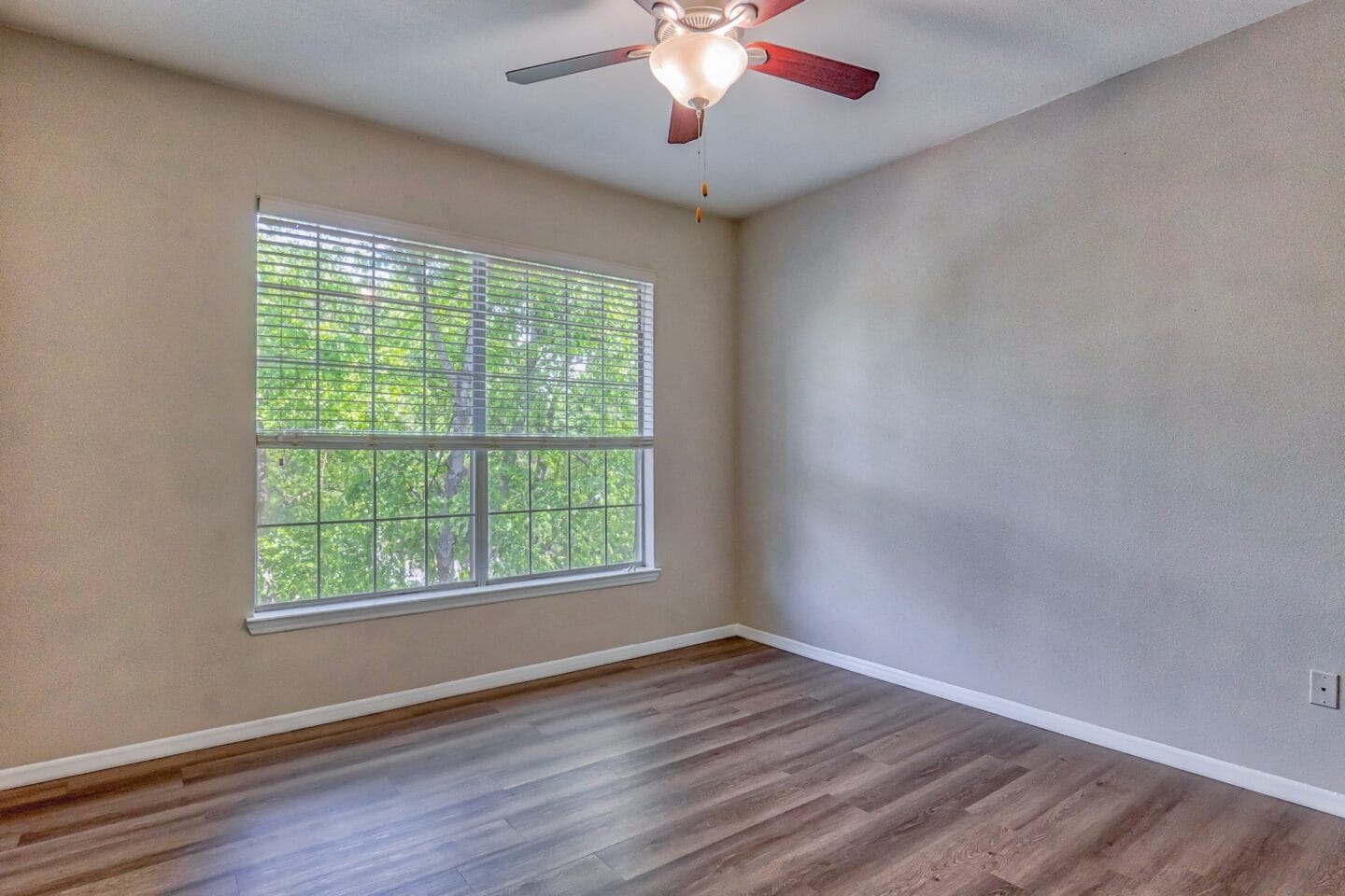 A bedroom with a large window and a ceiling fan at Windsor Addison Park, Charlotte, NC