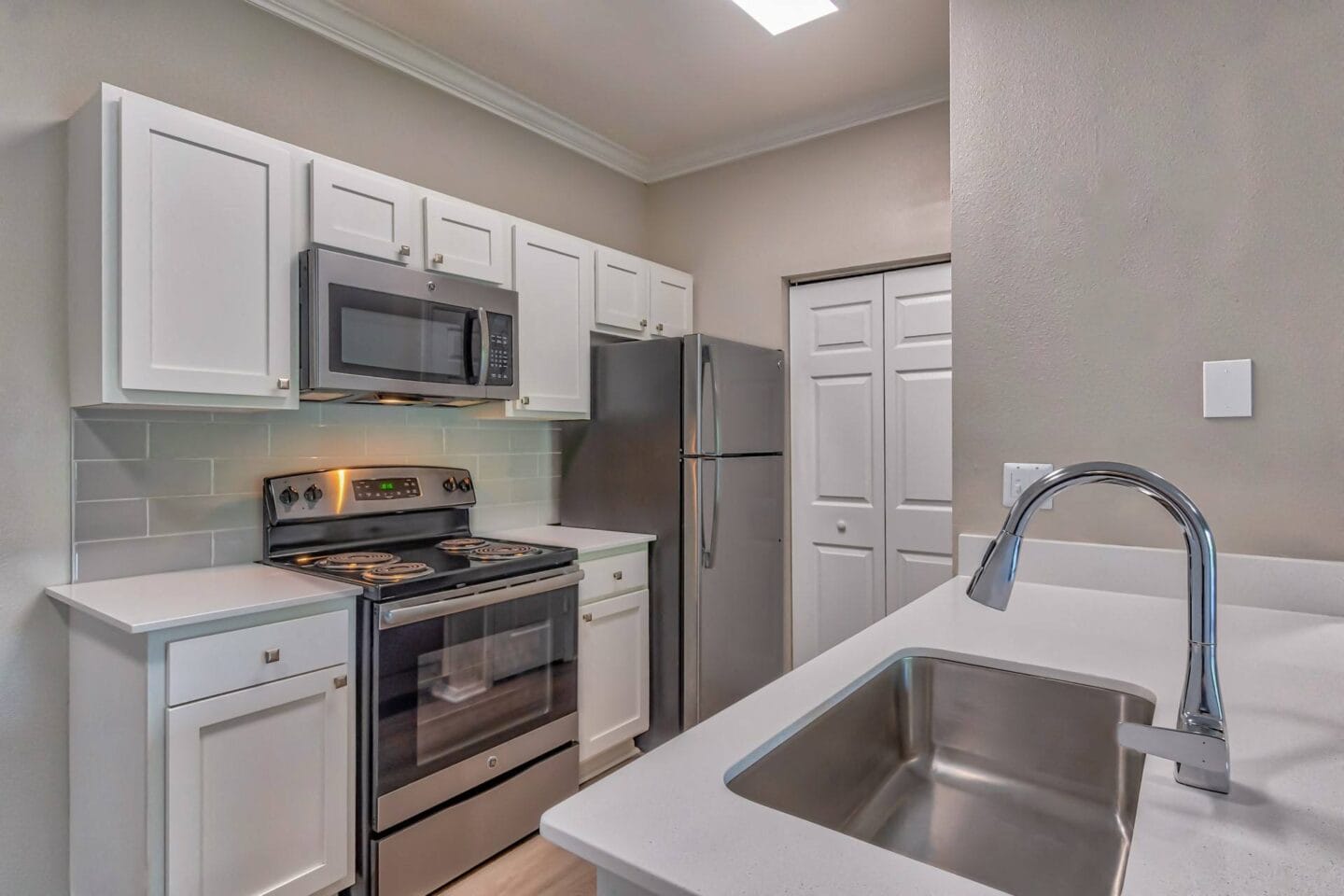 A kitchen with white cabinets and stainless steel appliances