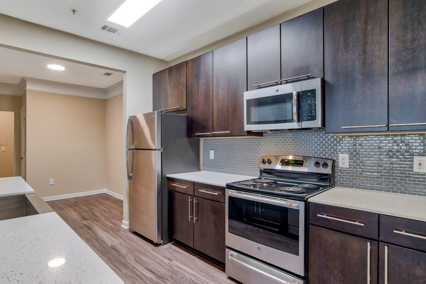 a kitchen with dark wood cabinets and stainless steel appliances