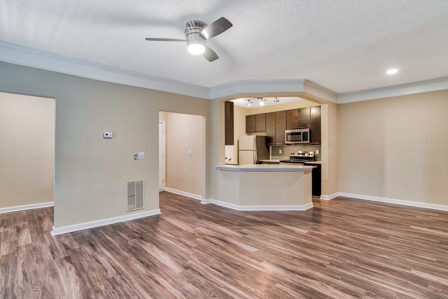 a living room with a kitchen in the background