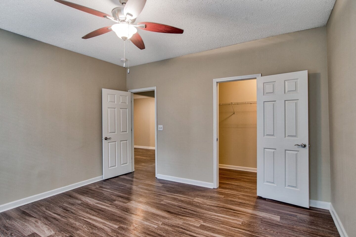 a living room with hardwood floors and a ceiling fan