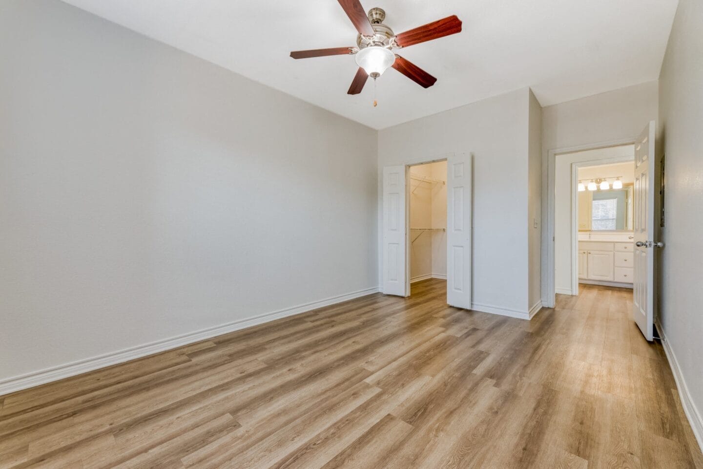 Bedroom with hardwood floors and a ceiling fan at Windsor Westbridge, Carrollton, TX