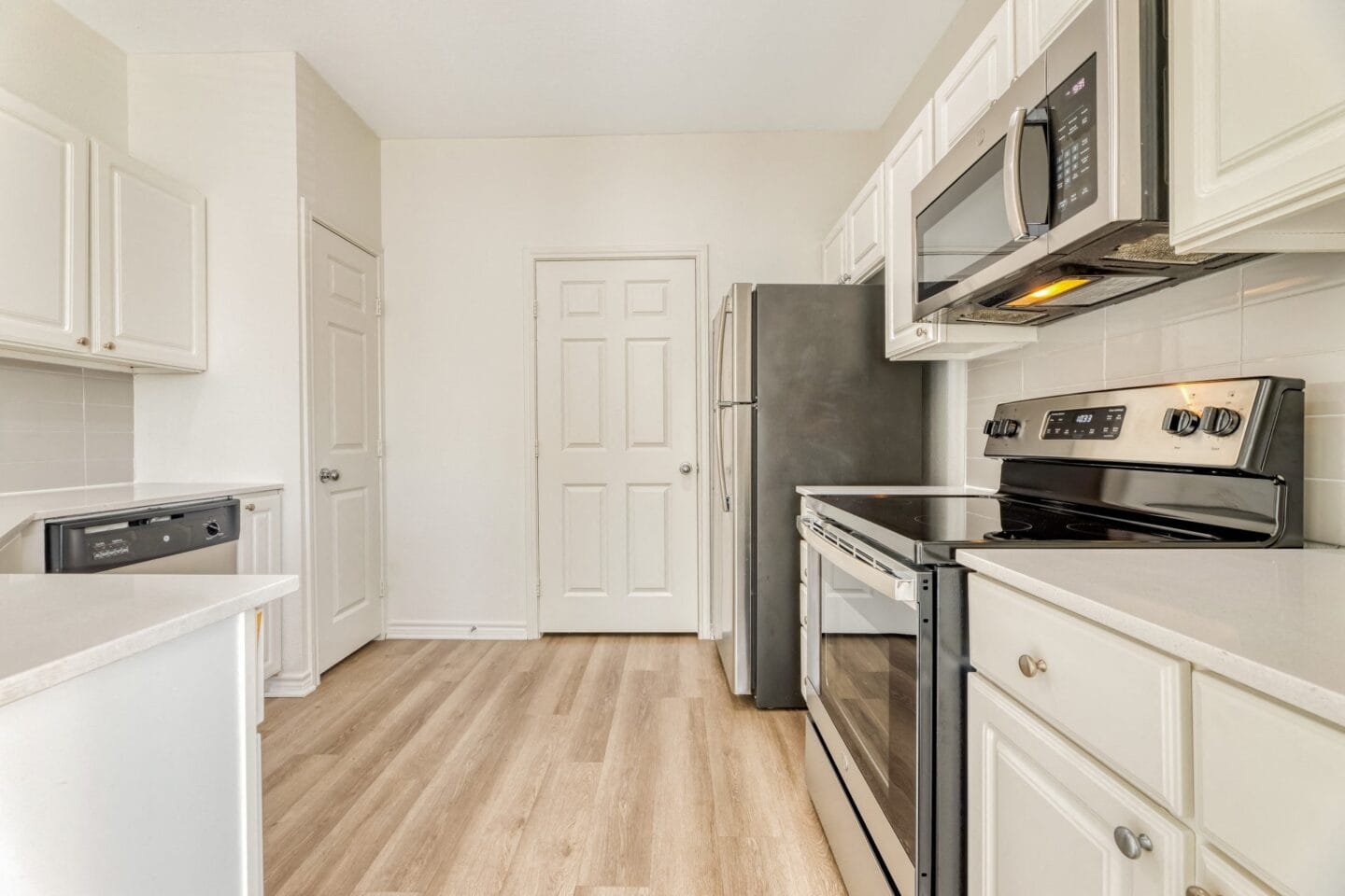 Kitchen with white cabinets and stainless steel appliances at Windsor Westbridge, Carrollton, TX