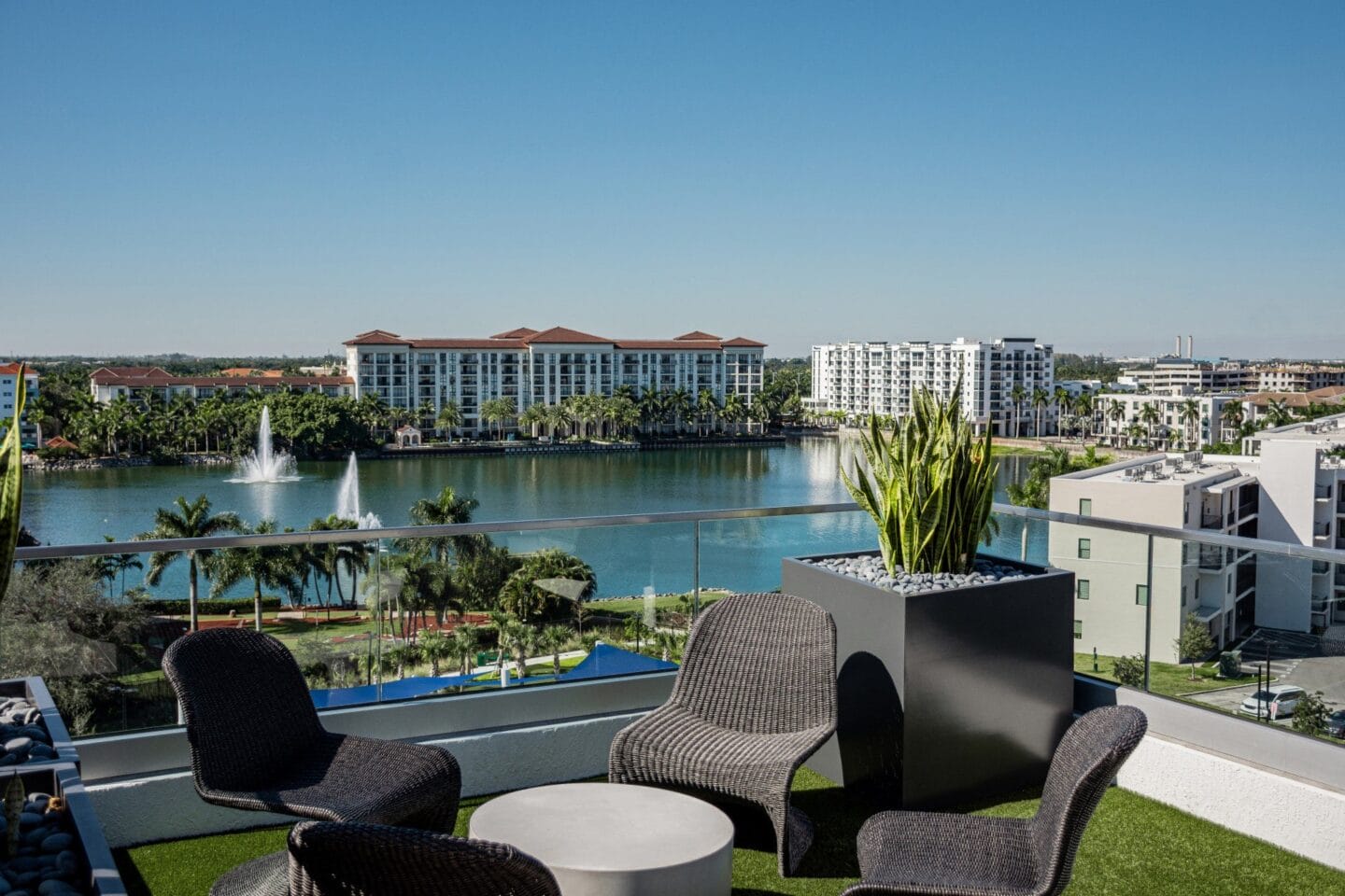 a balcony with chairs and a table overlooking a body of water