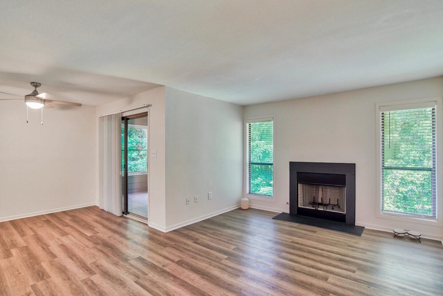 A living room with hardwood floors and a fireplace at Windsor Peachtree Corners, Peachtree Corners, GA