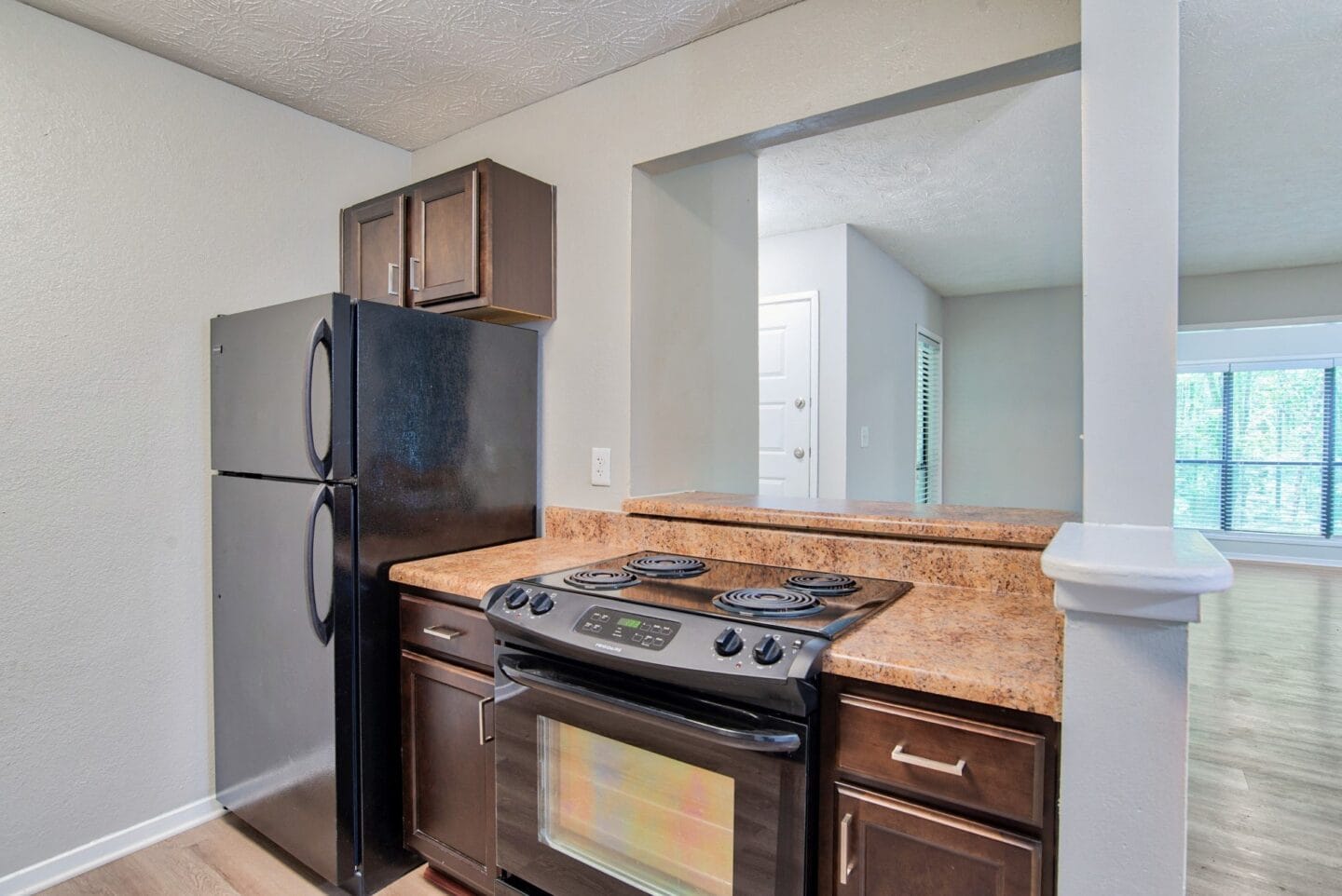 Kitchen with brown cabinets at Windsor Peachtree Corners, Peachtree Corners, GA