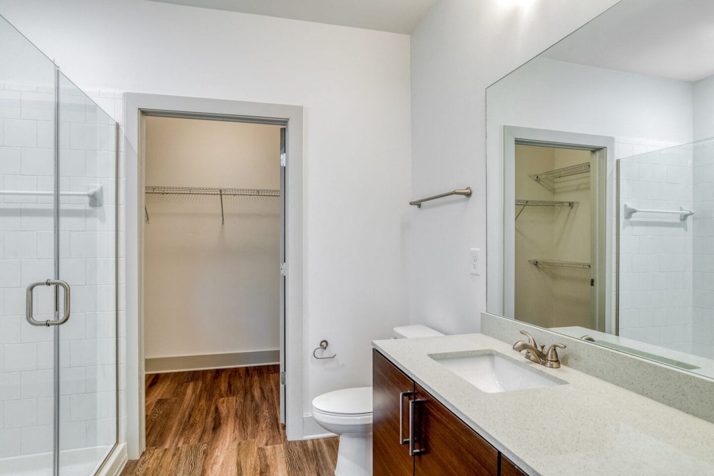 Bathroom with walk-in shower, large closet, and quartz countertops