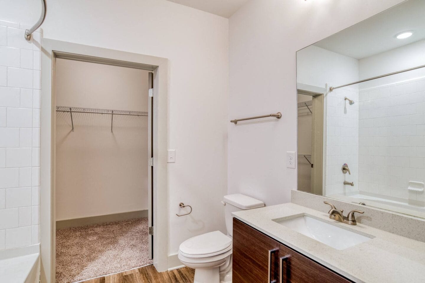 Bathroom with walk-in shower, large closet, and quartz countertops