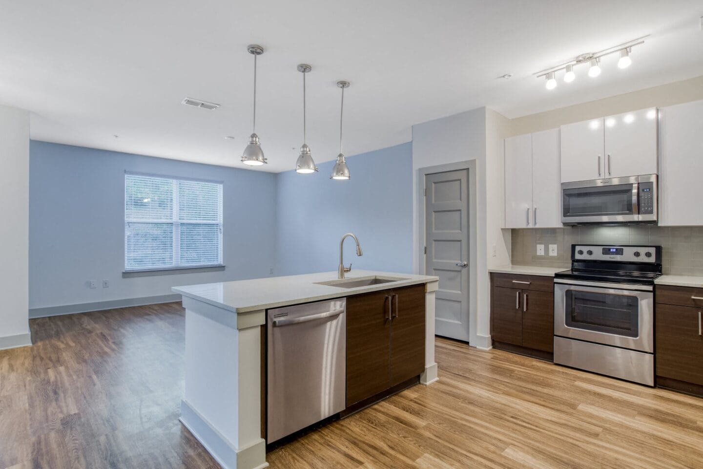 Kitchen with plank flooring, quartz countertops, and stainless steel appliances