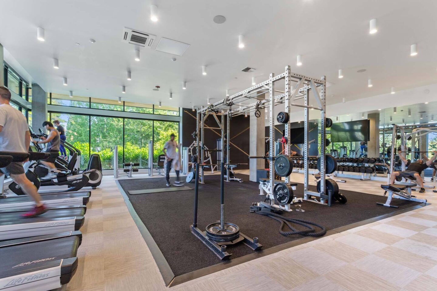 A gym with treadmills, weights, and people working out at Windsor Totem Lake, 11723 NE 117th Ct, Kirkland, WA 98034.