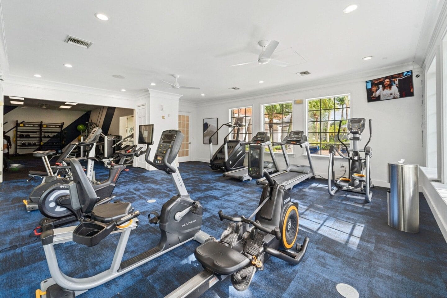 A gym with cardio equipment and a flat screen tv at Windsor Coral Springs, Coral Springs, FL