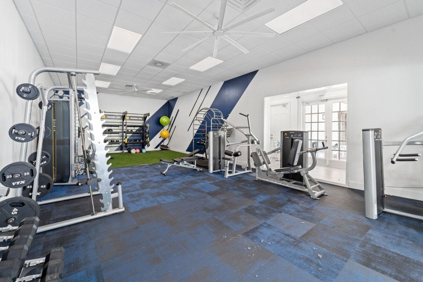 A large fitness room with weights and other exercise equipment at Windsor Coral Springs, Coral Springs, FL