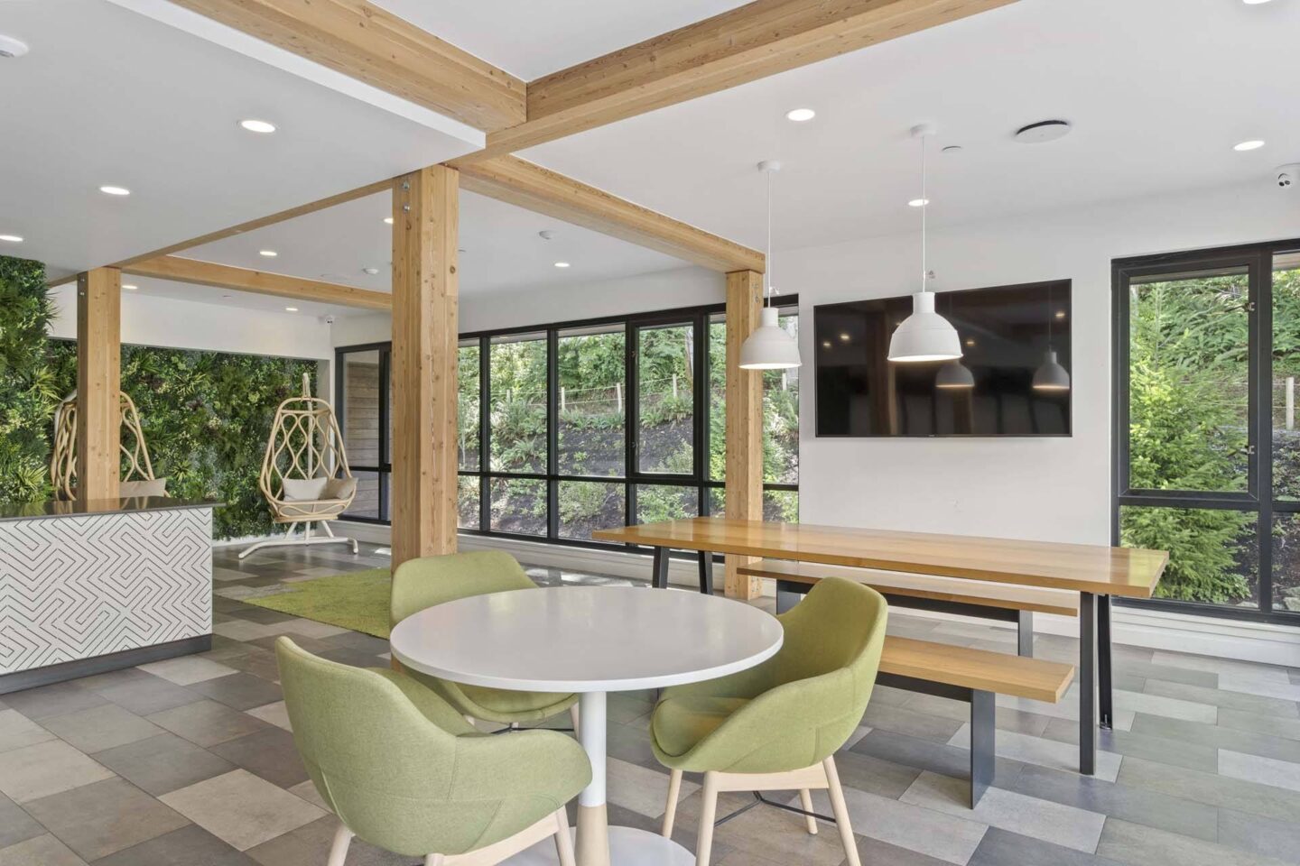 A modern dining room with a white table and green chairs.