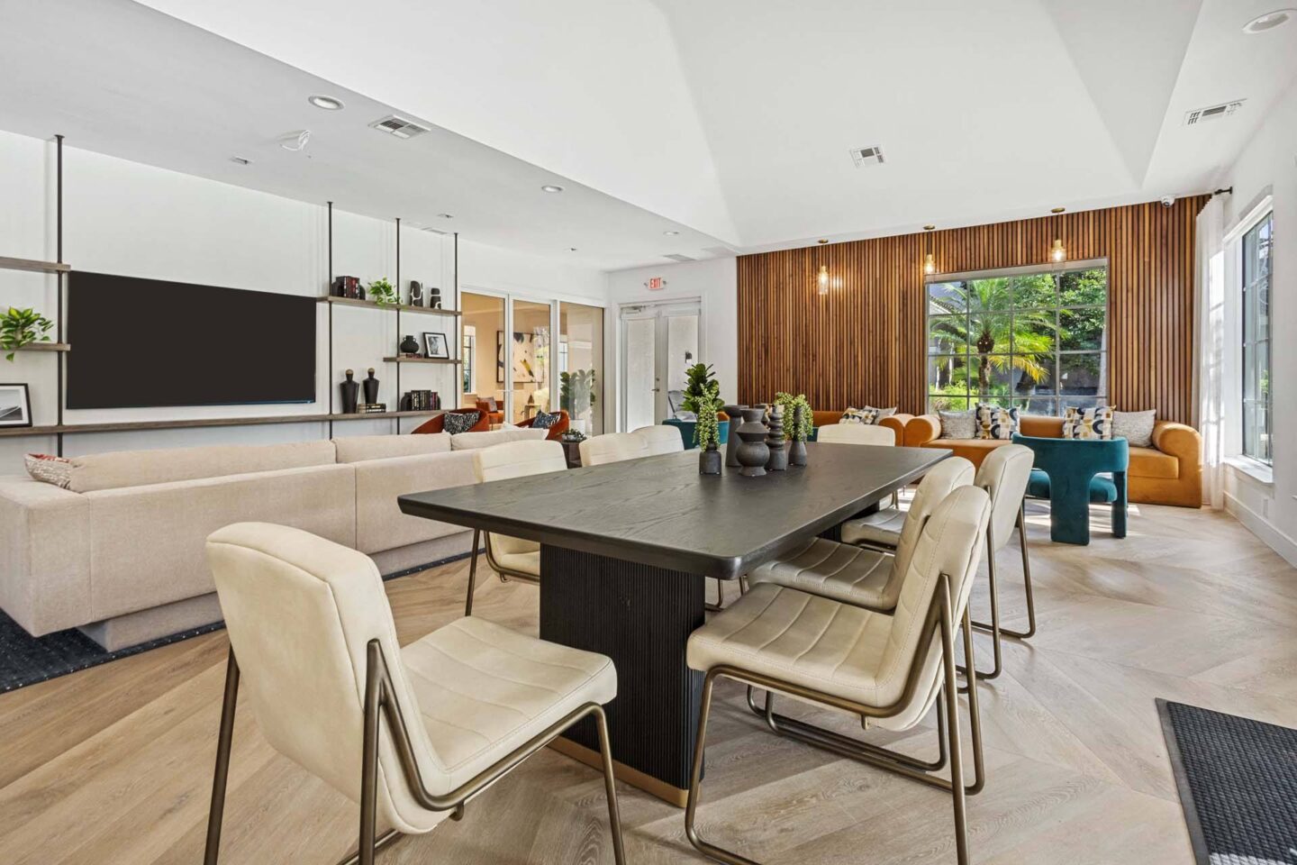 A modern lounge with a black table and beige chairs at Windsor Coconut Creek, Coconut Creek, 33073.