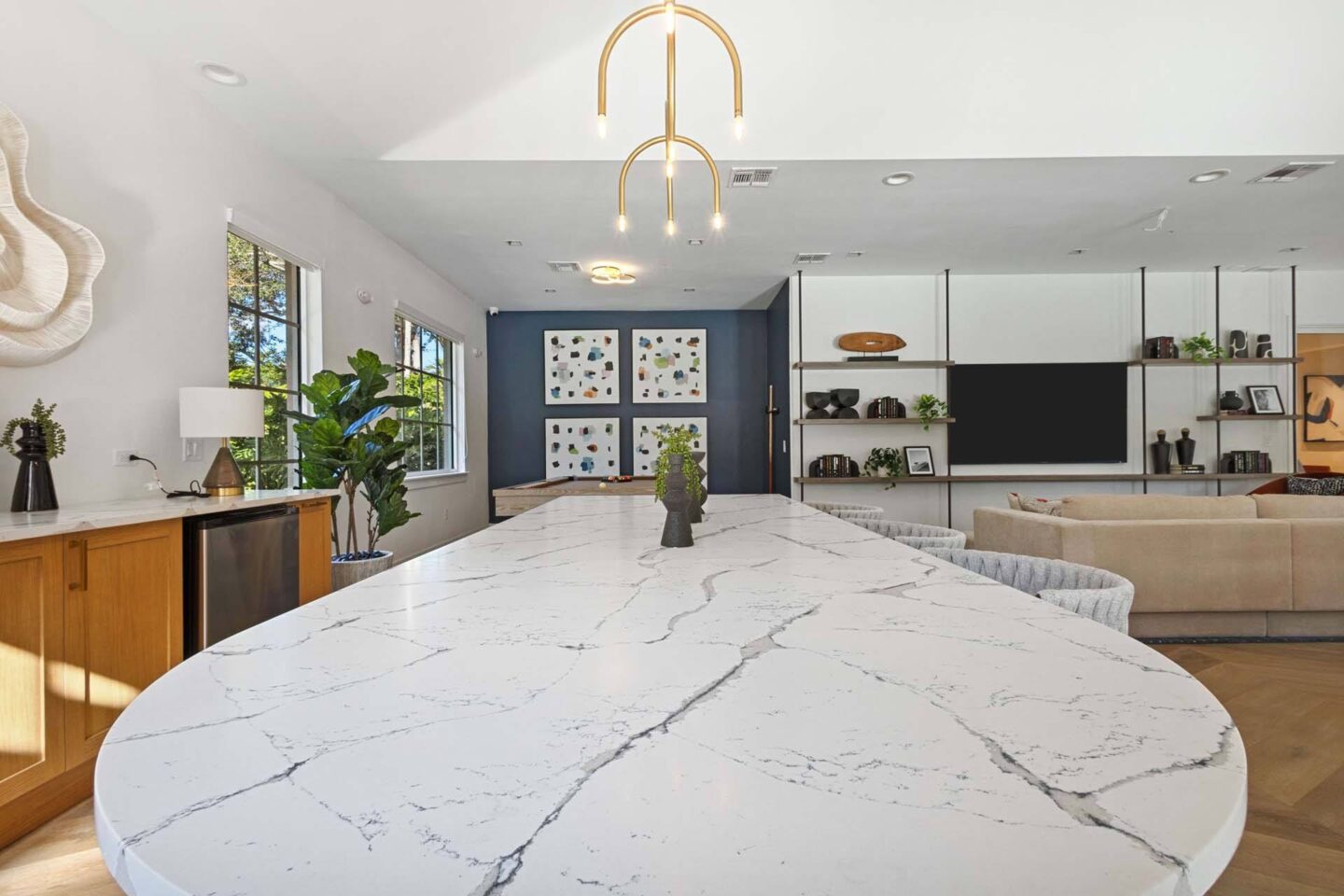 A kitchen with a marble table top and a hanging light fixture.