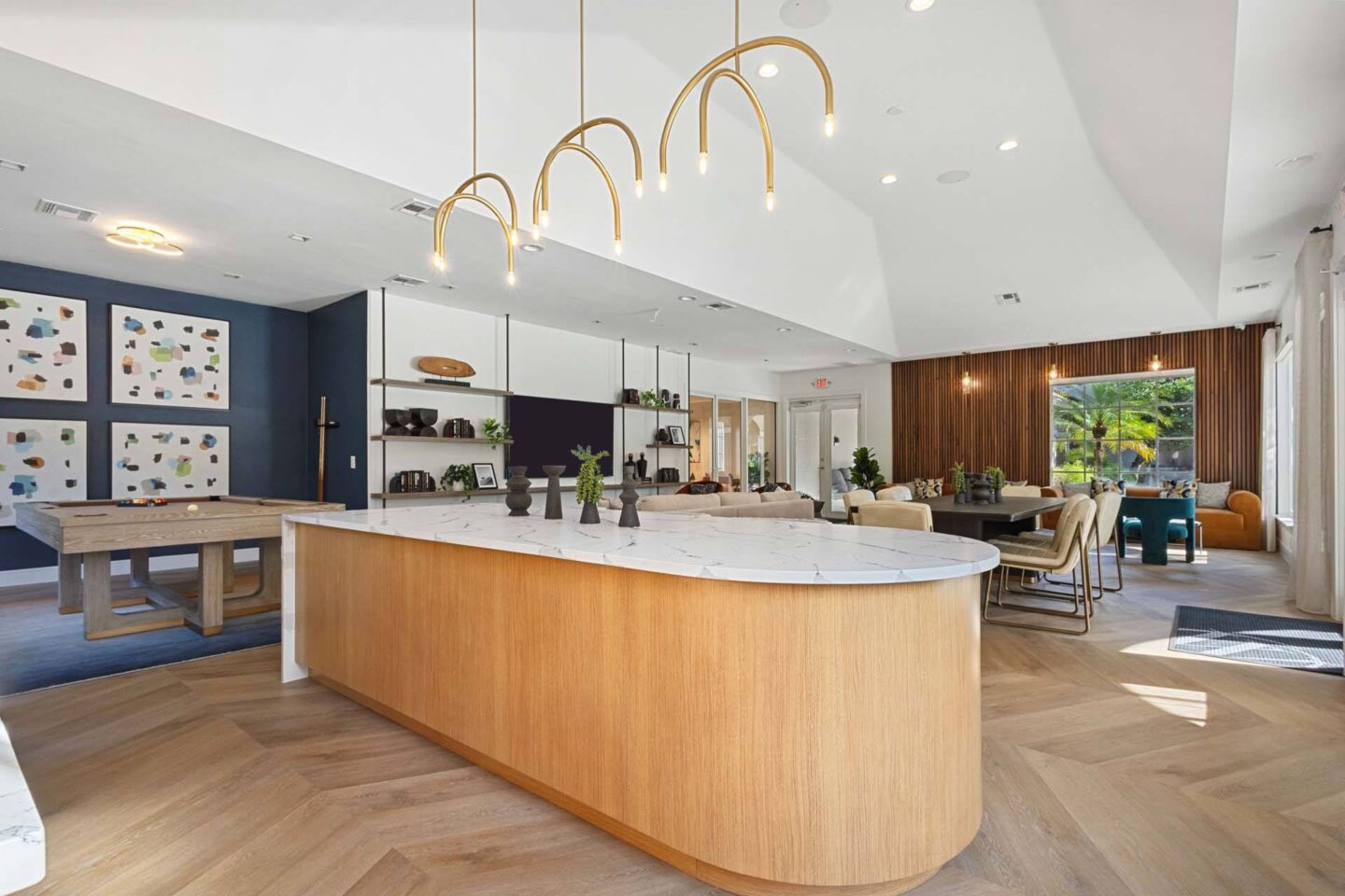 A modern kitchen with a wooden island and pendant lights.