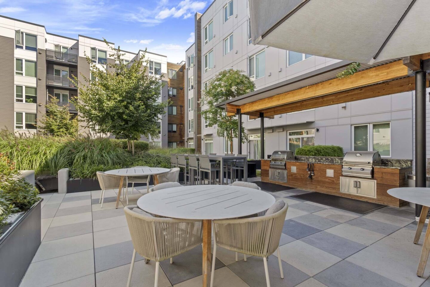 A patio with a table and chairs is surrounded by buildings at Windsor Totem Lake, 11723 NE 117th Ct, Kirkland, WA 98034.